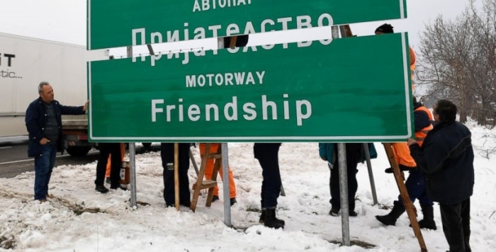 Workers install a new road sign on the highway linking the capital Skopje with northern Greece, on Friday, March 2, 2018. Macedonian authorities have begun installing new road signs on the countrys main highway named by the previous government after