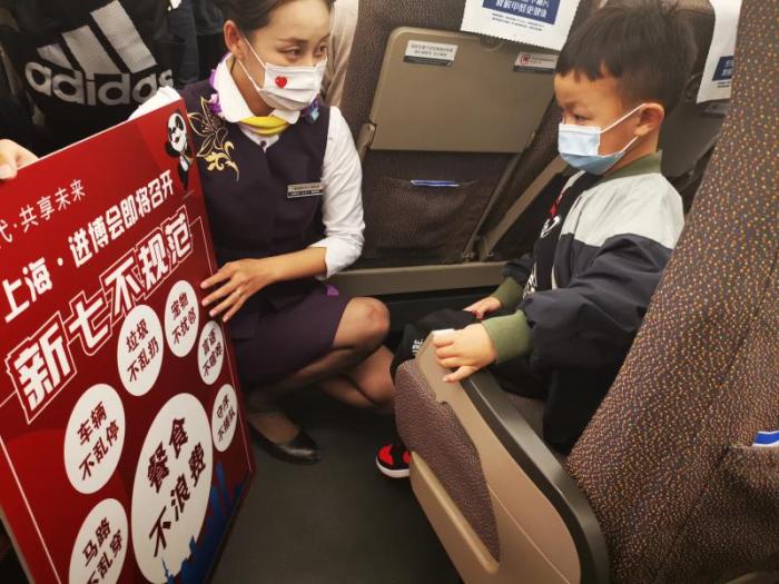 上海客运段乘务人员向旅客宣传“新七不规范”。    王闻强 摄