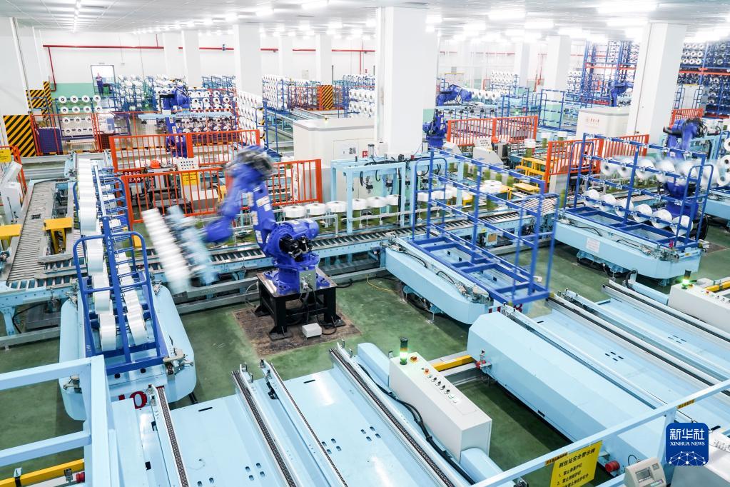 在位于江苏省苏州市吴江区盛泽镇的一家智能车间，机器人在车间内自动作业（2021年5月14日摄）。新华社记者 李博 摄